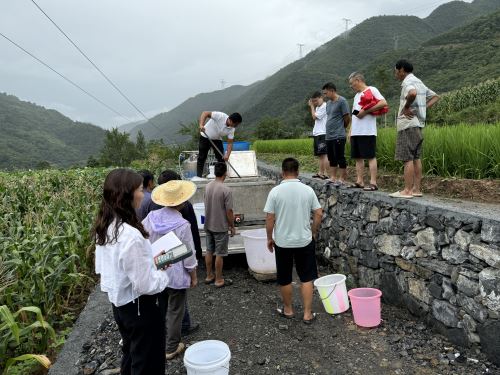 鱼苗运输车四周围着前来领取鱼苗的村民