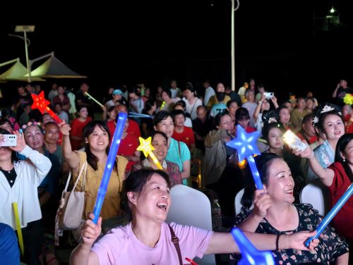 台下观众挥舞手里的荧光棒，为参赛选手加油助威